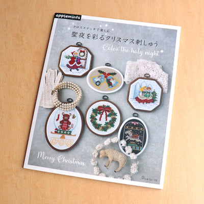 Front cover of the Christmas Collection Cross Stitch Book featuring a beautifully stitched holiday wreath and traditional winter scene.
