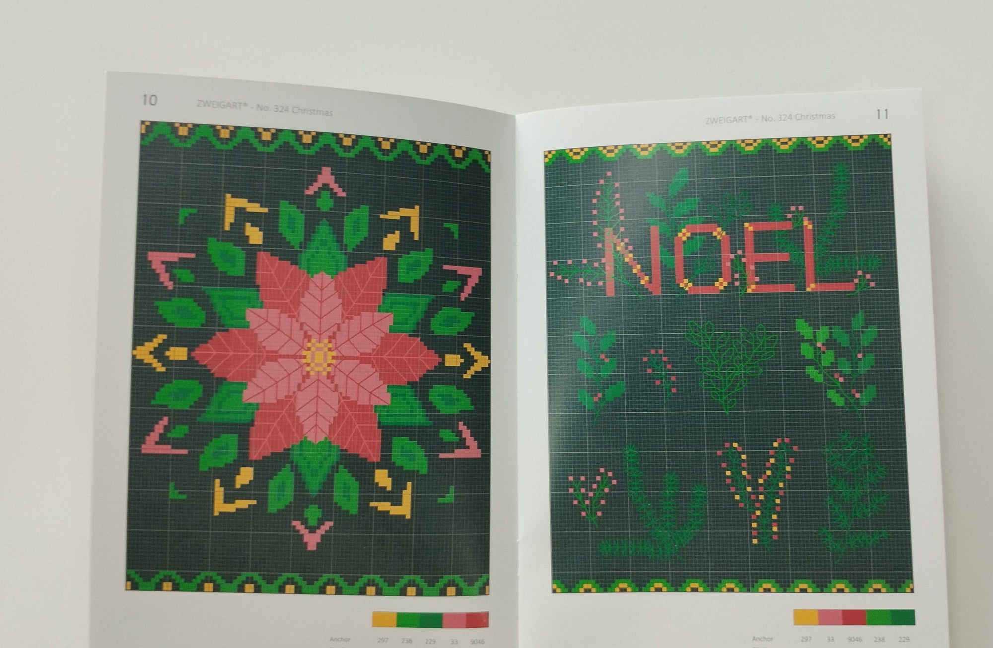 Open book with cross-stitch patterns, one featuring 'NOEL' and a poinsettia design.