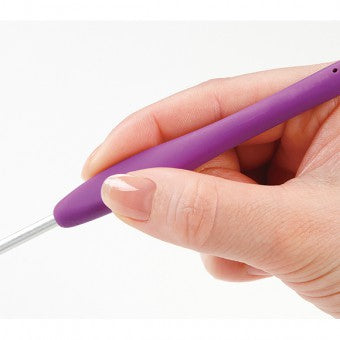 A hand holding a purple Clover Amour Crochet Hook. A hand comfortably holding a bright green 4.0mm Clover Amour hook while crocheting with soft yarn