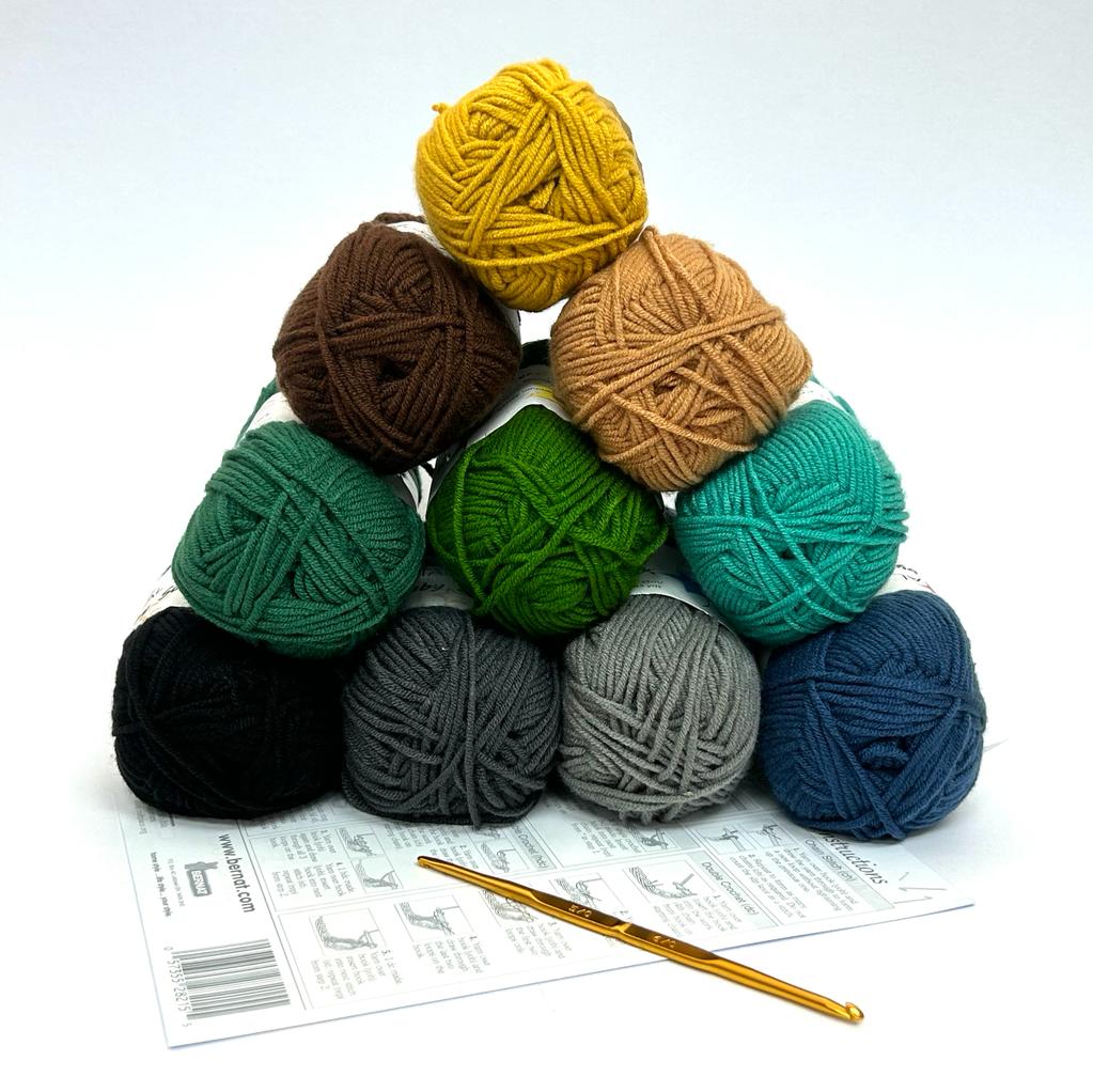 A calming and rustic crochet starter kit featuring ten 50g balls of 100% acrylic yarn in a variety of earth tones, including olive green, burnt orange, slate blue, and warm browns. The kit includes a premium Japanese Tulip double-sided crochet hook (3.0mm/3.5mm) and an English instruction guide, presented as an ideal gift for beginners starting their crochet journey