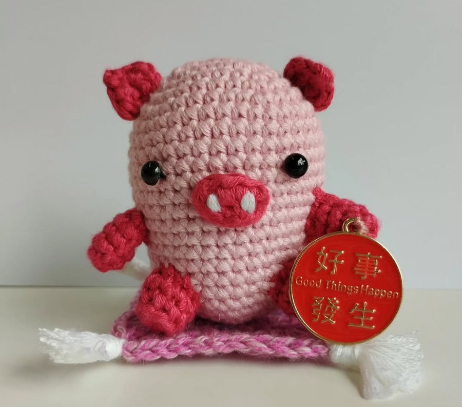 Pink crochet pig with red metal tag. gift giving idea. good fortune. hand crochet for sale. Amigurumi hand made