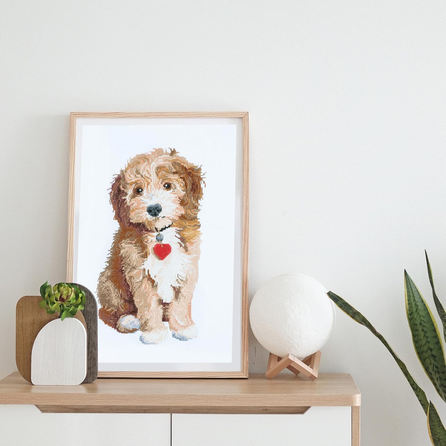 Trimits beginner Cross stitch kit. Cross stitch a dog with a heart on a white wall