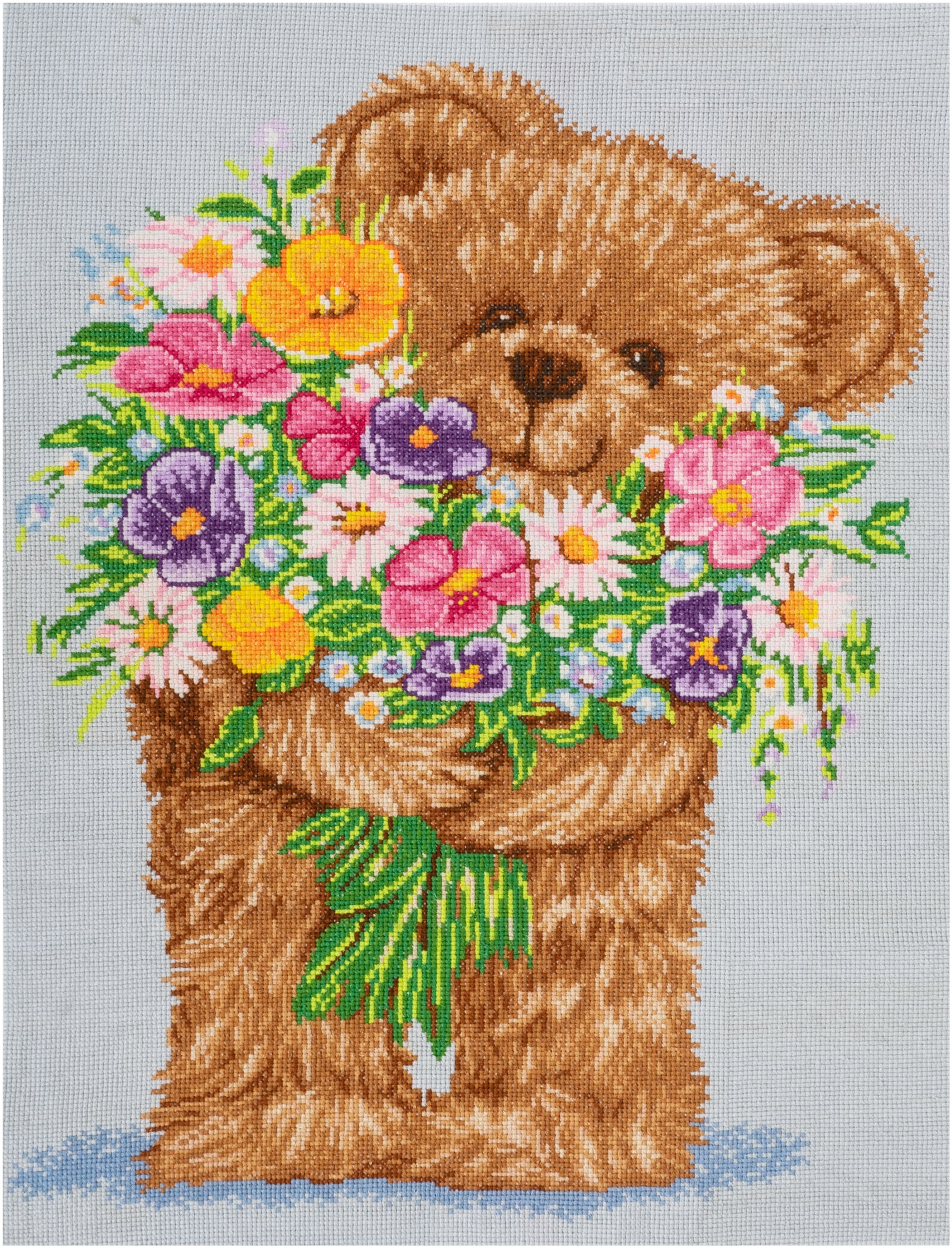 Trimits Mini Cross Stitch Kit featuring a cute Teddy Bear holding a bouquet of colorful flowers. design; an easy starter embroidery kit for kids and beginners with all supplies included.