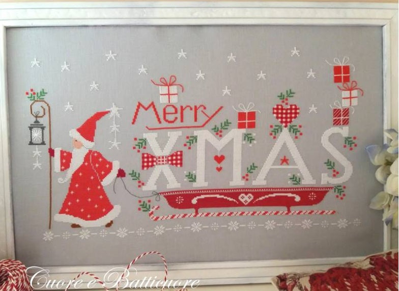 A professional-grade, large-scale cross-stitch chart by Italian designer Cuore e Batticuore titled 'Merry Xmas.' The high-definition design features a panoramic festive scene filled with boutique-style holiday motifs, including whimsical houses, vintage-inspired reindeer, and intricate floral and geometric borders.
