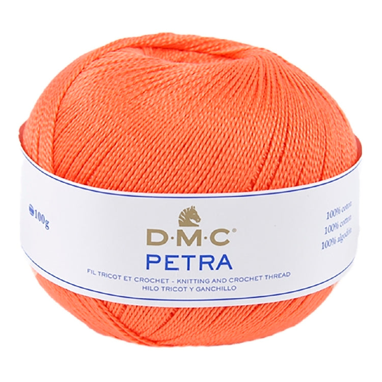 A ball of bright orange DMC Petra knitting and crochet thread with a white paper label, shown on a plain white background.