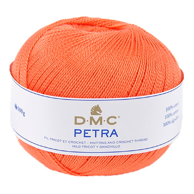 A ball of bright orange DMC Petra knitting and crochet thread with a white paper label, shown on a plain white background.