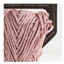 A donut of Daruma Sasawashi Flat yarn, showing its sleek, ribbon-like structure and the natural, soft-gold luster of Kumasasa bamboo paper in sakura pink colour