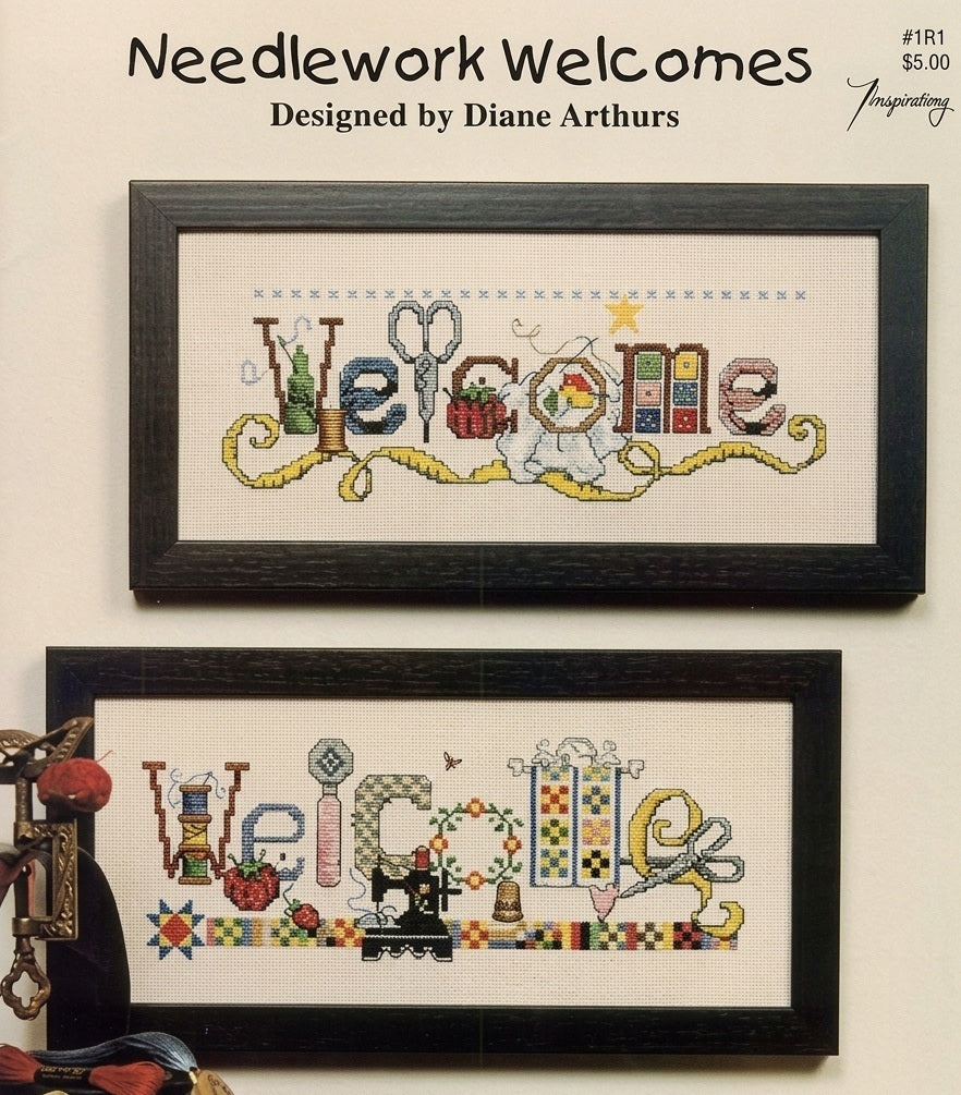 A complete dual cross-stitch kit designed by Diane Arthurs titled 'Needlework Welcomes.' The kit includes patterns for two vertical welcome signs: one featuring quilting motifs like patchwork blocks and needles, and the other featuring sewing icons like thread spools and scissors
