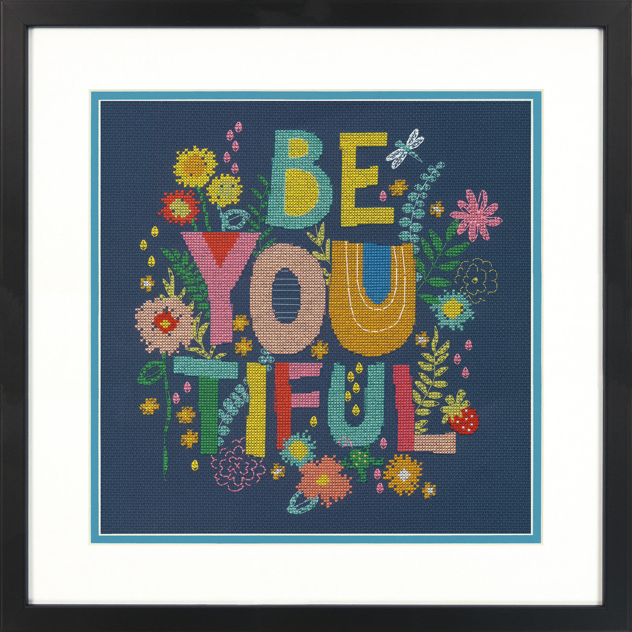A cross stitch kit depicting the phrase 'BE YOU-TIFUL' surrounded by colorful floral designs on a navy background, presented in a frame.