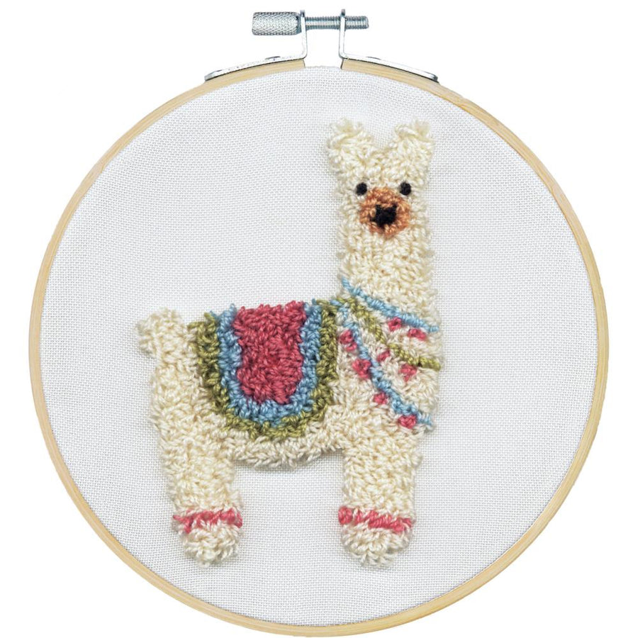 A professional-grade punch needle kit by Dimensions featuring a colorful llama design. The high-definition package includes an 8-inch embroidery hoop, high-quality fabric printed with the llama template, pre-sorted wool yarn in vibrant colors, and a specialized punch needle tool. The kit layout highlights a complete, all-in-one artisanal experience designed to guide beginners and experienced makers alike through a texturally rich, successful crafting project.
