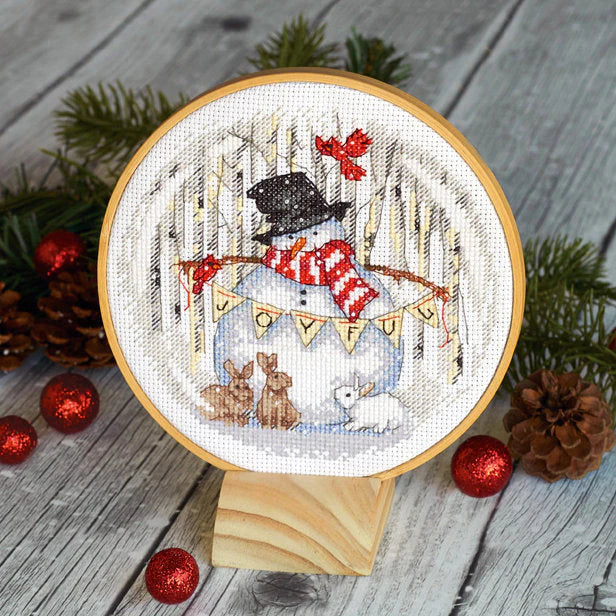 Dimensions 'Joyful Snow Globe' Cross Stitch Kit featuring a festive holiday scene with a smiling snowman inside a decorative glass globe, surrounded by a classic winter landscape