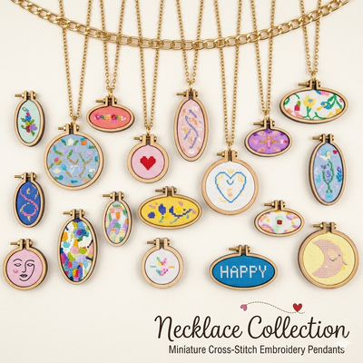 Necklace collection with miniature cross-stitch embroidery pendants on a white background