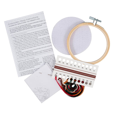 Embroidery hoop kit with instructions, thread, and hoop on a white background