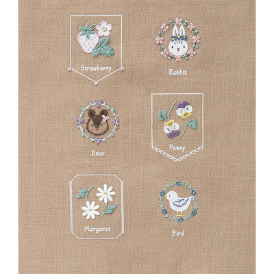 Beginner Friendly Japanese Embroidery, Cosmo Embroidery Floss Kit, Floral Folksy Stitching Project.
A variety of embroidered designs on a yellow background, including a strawberry, a rabbit, a bee, a pomegranate, a daisy, and a bird, each within their own bordered frame.