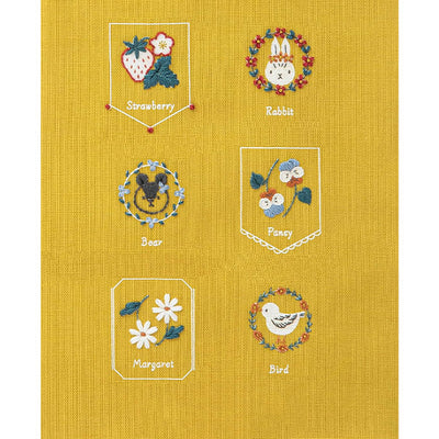 Beginner Friendly Japanese Embroidery, Cosmo Embroidery Floss Kit, Floral Folksy Stitching Project.
A variety of embroidered designs on a yellow background, including a strawberry, a rabbit, a bee, a pomegranate, a daisy, and a bird, each within their own bordered frame.
