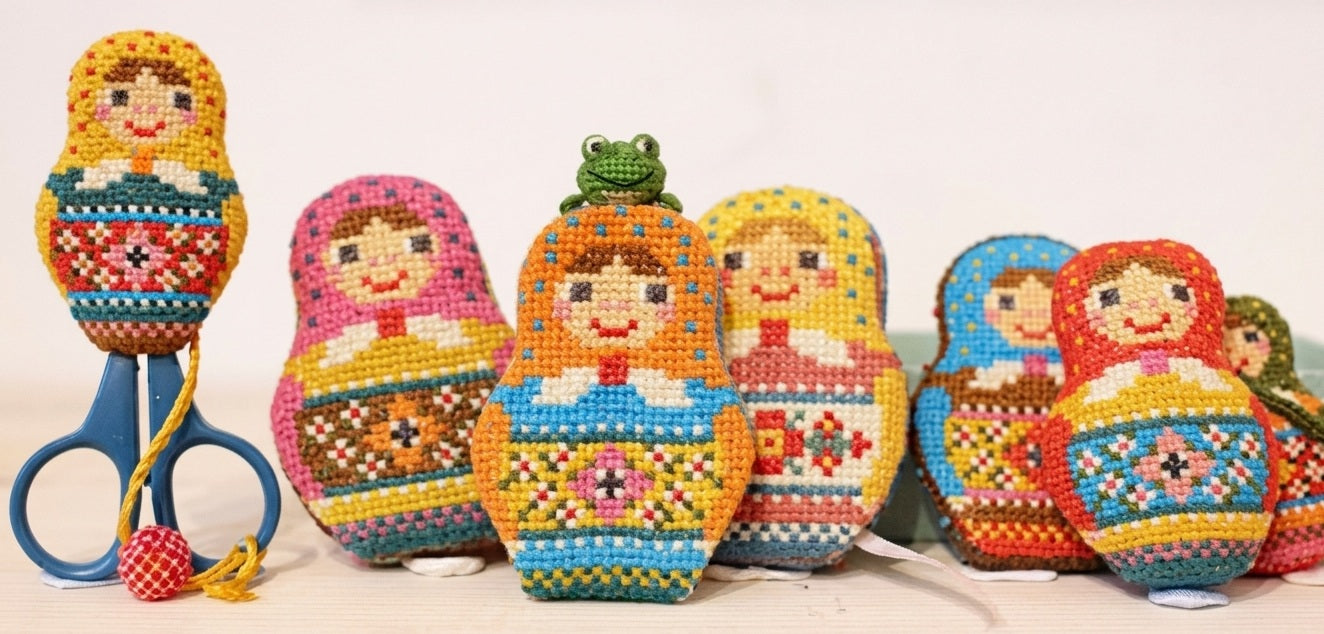 A professional cross-stitch chart by Japanese designer Kyoko Maruoka of GERA! featuring a whimsical Matryoshka (Russian nesting doll) design.