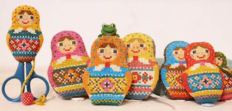 A professional cross-stitch chart by Japanese designer Kyoko Maruoka of GERA! featuring a whimsical Matryoshka (Russian nesting doll) design.