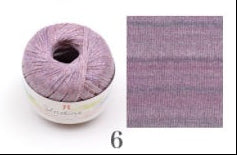 Spool of purple yarn and fabric swatch next to each other