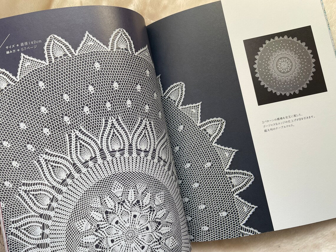 Open copy of the Japanese Crochet Lace book sitting on a wooden table next to a crochet hook and fine cotton yarn.