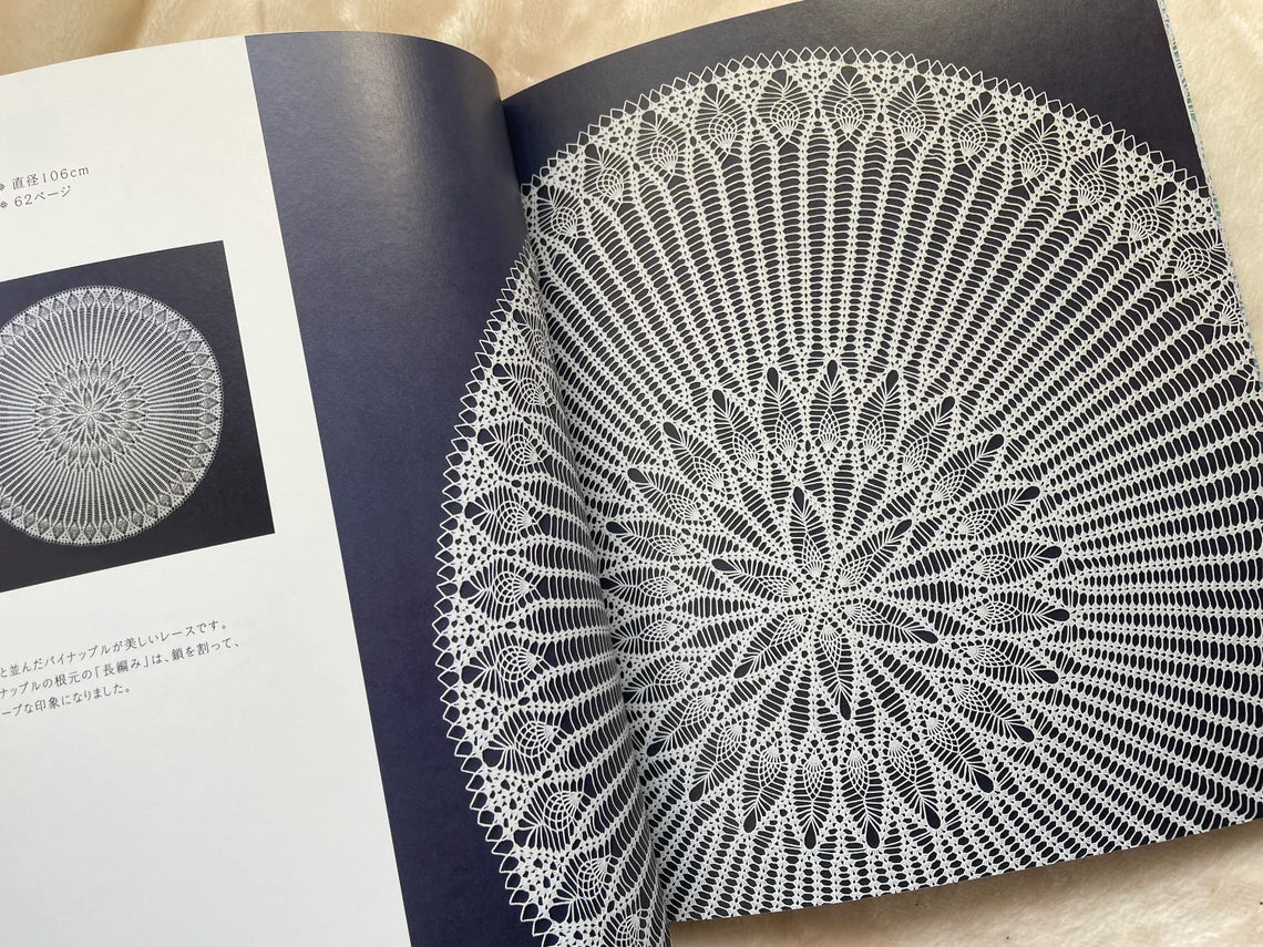Open copy of the Japanese Crochet Lace book sitting on a wooden table next to a crochet hook and fine cotton yarn