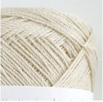 A luxurious 40g ball of Pierrot Julien 100% Silk yarn in a soft champagne gold, showcasing its brilliant natural luster in ivory white. Pure silk fingering yarn, high-drape silk yarn, breathable summer yarn, silk for lace shawls, premium Japanese needlecraft supplies.
