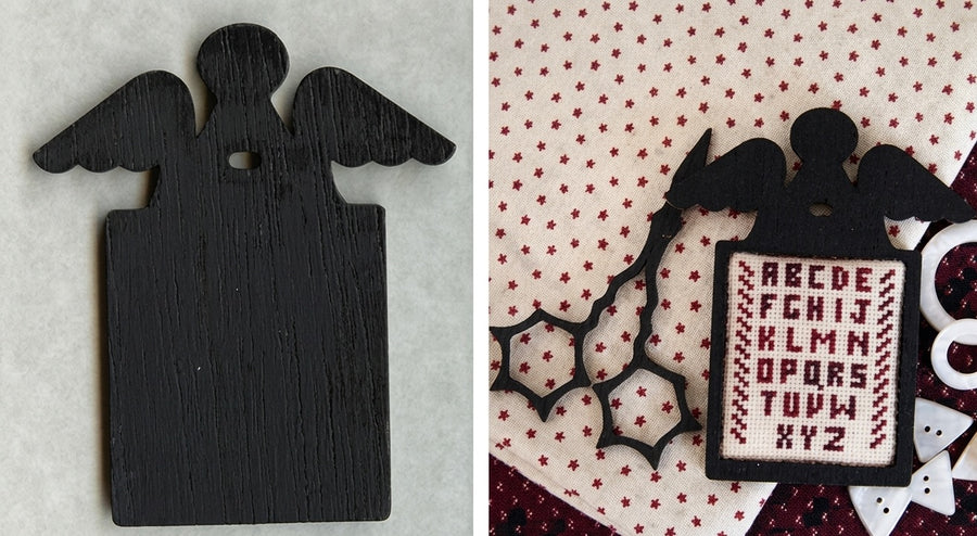 A professional-grade counted needlework chart package from Kelmscott Designs titled 'Tombstone Angel.' The high-definition product features a boutique primitive folk art cross-stitch pattern alongside an exclusive, custom hand-painted wooden angel shape modeled after historic colonial headstone carvings, designed to be mounted onto the finished stitching. The kit is an artisanal package containing the template and detailed step-by-step structural finishing instructions.