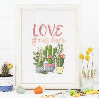 A comprehensive cross stitch book containing multiple charts for creating personalized home decor, including kitchen-themed motifs, welcome signs, and cozy living space patterns.