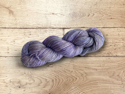 Skein of vibrant, variegated Manos del Uruguay Bambok yarn, displaying unique color pooling and glossy finish.