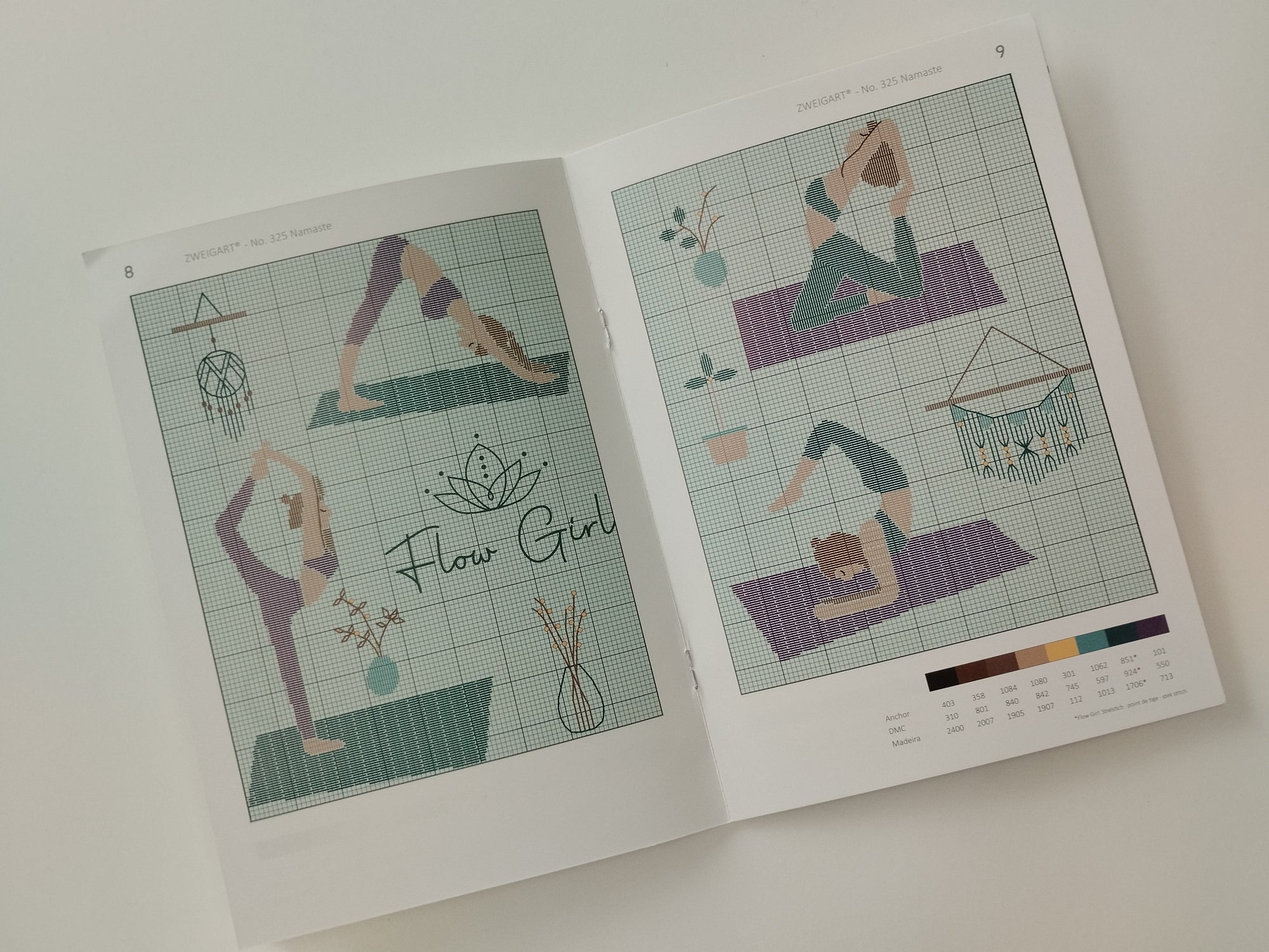 Yoga-themed cross-stitch pattern book on a white background