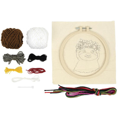 A complete Needle Creation Sloth Punch Needle Kit, featuring a pre-printed fabric panel, an embroidery hoop, vibrant yarn, and a punch needle tool for creating a textured, 3D sloth design.