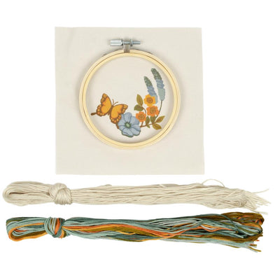 A complete Needle Creations Punch Needle Kit featuring a butterfly and floral design, including a pre-printed fabric panel, an embroidery hoop and colorful threads