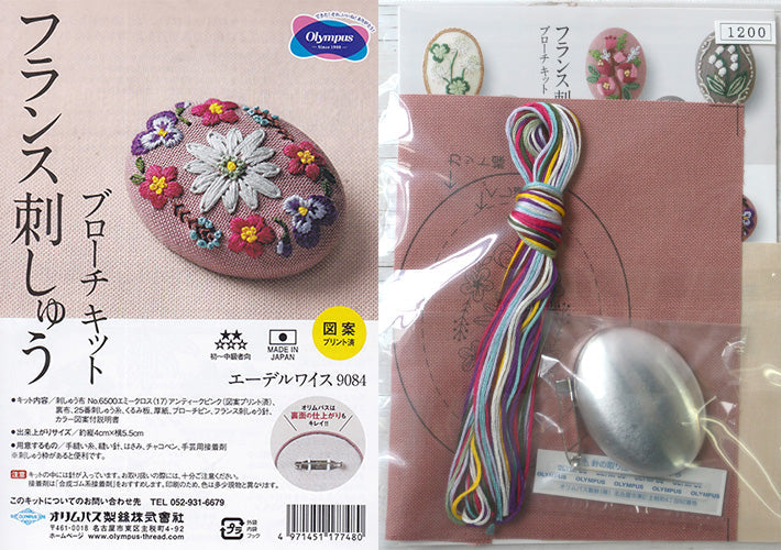 An Olympus embroidery brooch kit from Japan, featuring a pre-printed cotton fabric with a delicate floral motif. The kit is displayed with vibrant 100% cotton embroidery threads, a specialized needle, and a silver-tone brooch pin, highlighting the easy-to-stitch 'printed design' feature