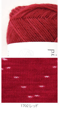 Red yarn ball with a label on a white background