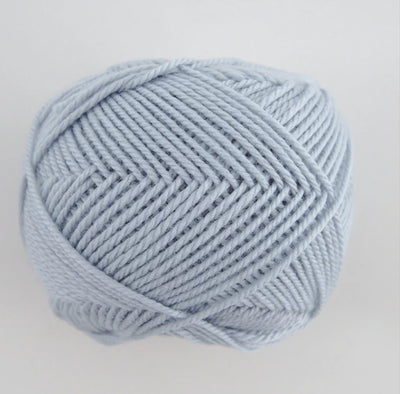 A 30g skein of Pierrot Fine Merino yarn in a soft matte finish, showing the delicate, tightly twisted 100% extra fine merino wool in frosty blue colour