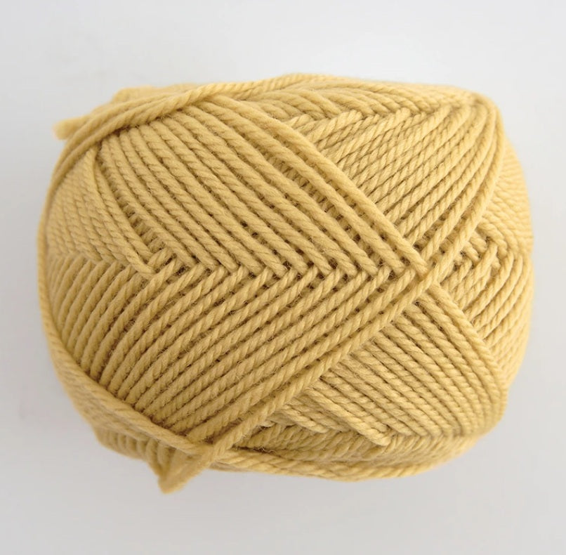 A 30g skein of Pierrot Fine Merino yarn in a soft matte finish, showing the delicate, tightly twisted 100% extra fine merino wool in mustard colour