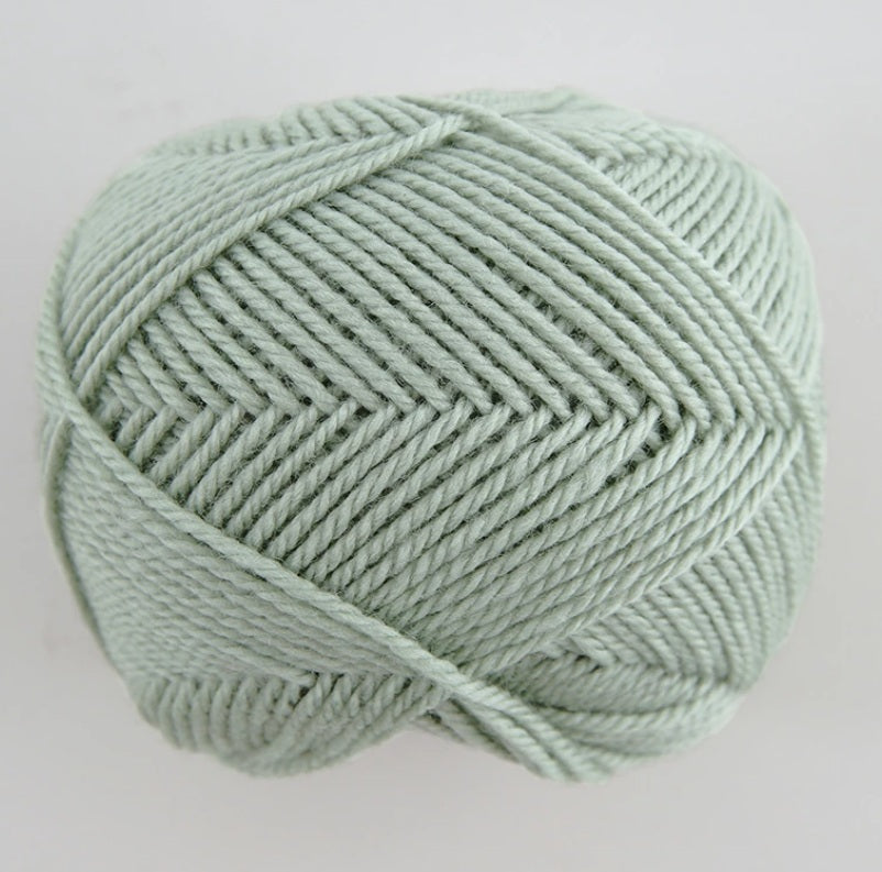 Close-up of premium Japanese Pierrot Fine Merino wool, showcasing the smooth, anti-pilling texture and fine weight suitable for intricate knitting in pale green colour