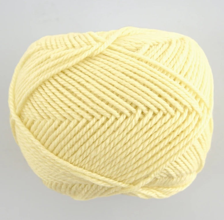 A 30g skein of Pierrot Fine Merino yarn in a soft matte finish, showing the delicate, tightly twisted 100% extra fine merino wool in pale yellow colour.