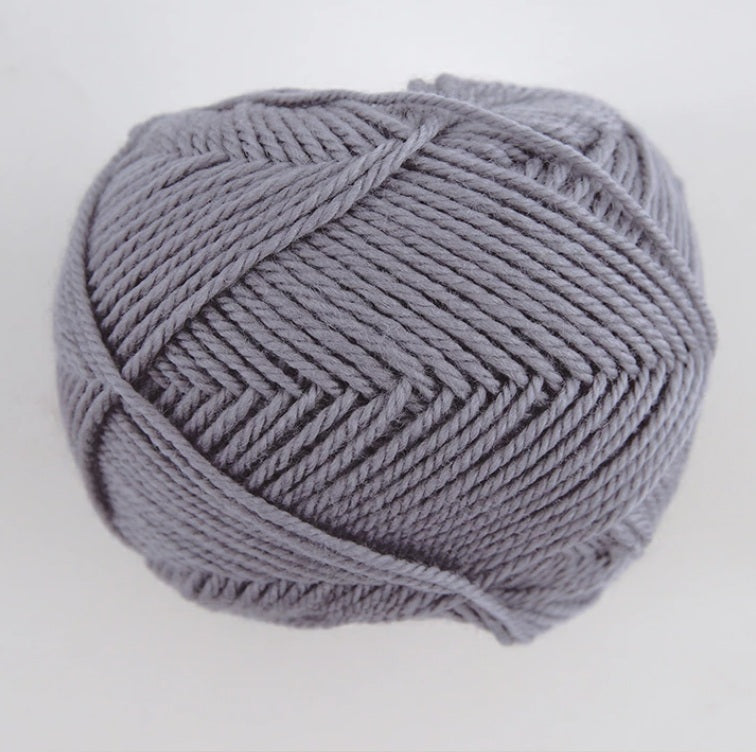 A 30g skein of Pierrot Fine Merino yarn in a soft matte finish, showing the delicate, tightly twisted 100% extra fine merino wool in ash grey colour.