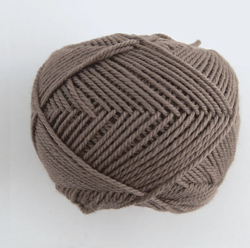 A 30g donut-style ball of Pierrot Fine Merino yarn. The image showcases the smooth, tightly spun plies of 100% Extra Fine Merino wool, reflecting the high-quality Japanese craftsmanship and the soft, matte finish characteristic of premium boutique yarns in cocoa brown colour