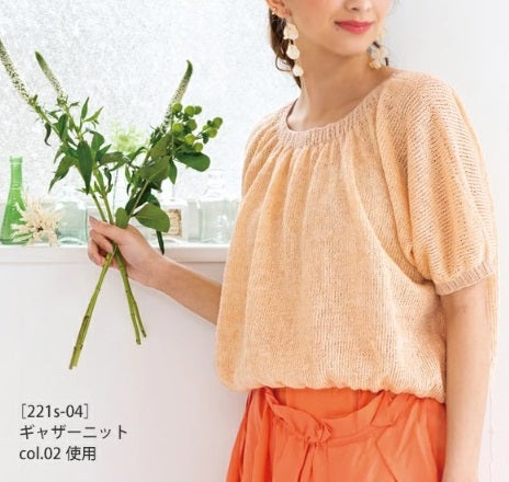 A model wearing a sheer, fine-knit summer blouse made with Pont du Gard linen, showcasing the yarn's elegant, cool-to-the-touch quality