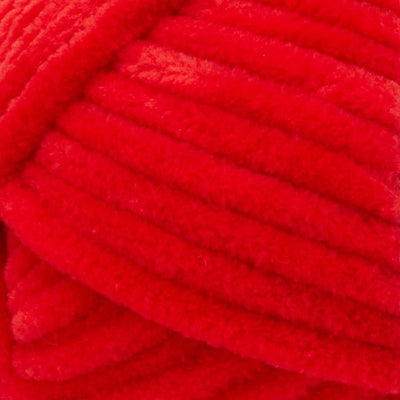 Close-up of Premier Parfait Chunky polyester yarn, highlighting the dense, plush pile and vibrant color in poppy red colour