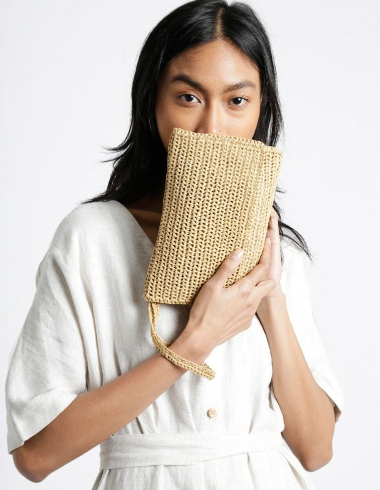 A durable roll of Ra-Ra Raffia yarn, ideal for crocheting structured summer sun hats, beach bags, and airy home decor accessories with a natural, rustic finish