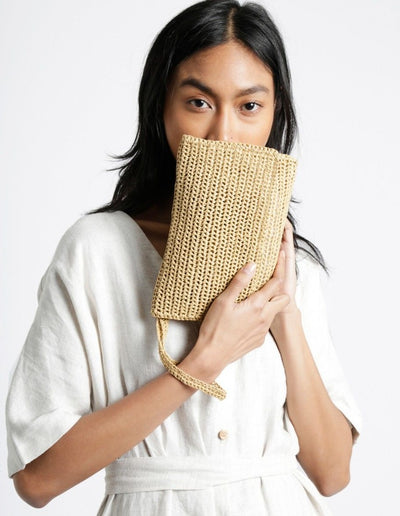 A durable roll of Ra-Ra Raffia yarn, ideal for crocheting structured summer sun hats, beach bags, and airy home decor accessories with a natural, rustic finish