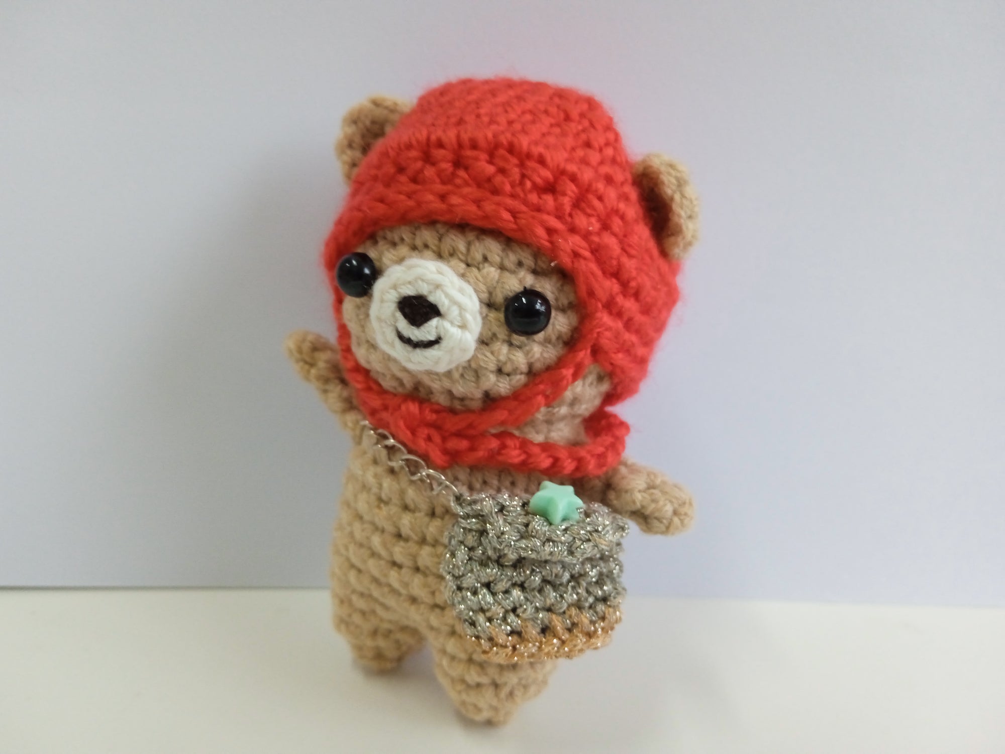 Crocheted mini teddy bear with a red hood and star sling bag on a white background. Artisan Made in Singapore. Crocheted item for Sale
Stuffed animal photography