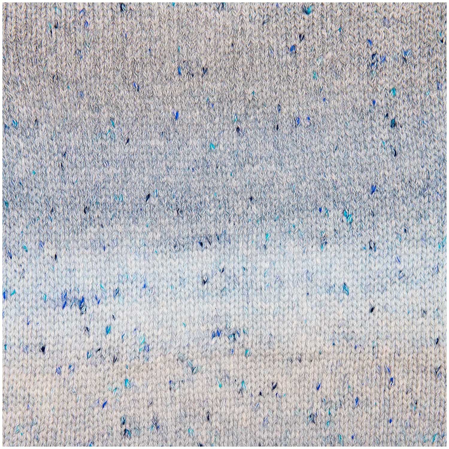 A knitted sample of Rico Fashion Cotton Light & Long Tweed, demonstrating the subtle ombré color flow combined with a speckled, heathered effect that adds depth and character to the stitches knitted in gradient of blue hues