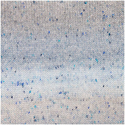 A knitted sample of Rico Fashion Cotton Light & Long Tweed, demonstrating the subtle ombré color flow combined with a speckled, heathered effect that adds depth and character to the stitches knitted in gradient of blue hues