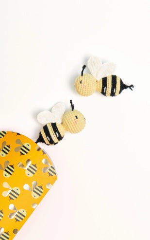 Close-up of the crocheted bee and cherry patterns, highlighting the neat stitch definition and vibrant Ricorumi cotton colors