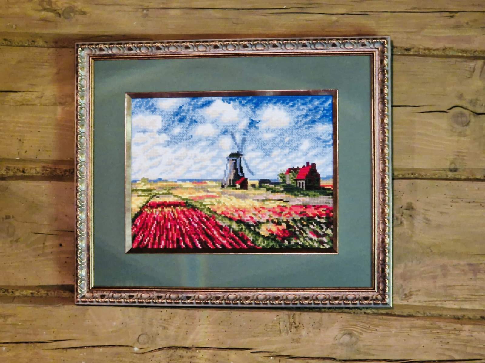 Cross stitch kit depicting a colorful landscape with a windmill, tulips, and a clear sky, framed in a wooden frame.
Riolis Tulip Field Counted Cross Stitch Kit after Claude Monet. Premium Impressionist art embroidery set on 14ct Aida with wool-blend threads for a soft, painterly finish