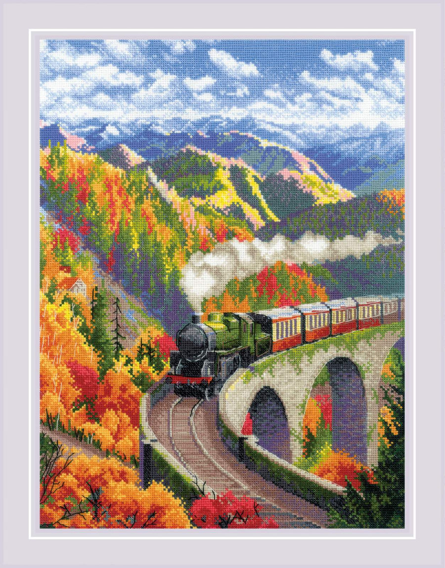 A colorful cross stitch kit image featuring a steam locomotive on tracks with autumn colors in the background, including red and yellow leaves and a blue sky.