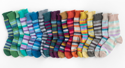 Hand-knitted sock featuring the vibrant stripes of Scheepjes Downtown yarn, highlighting smooth stitch definition.